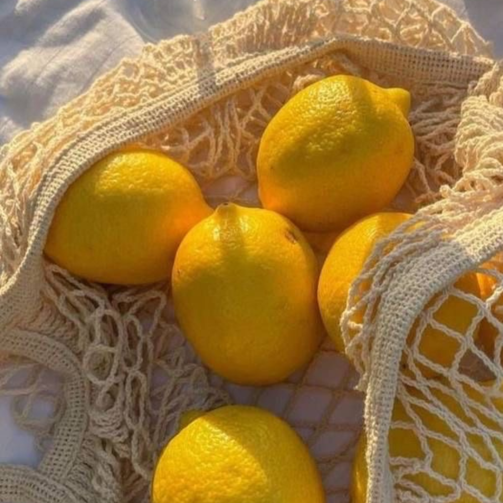 Ein ästhetisches Bild von Zitronen in einem Netzbeutel aus Baumwolle.