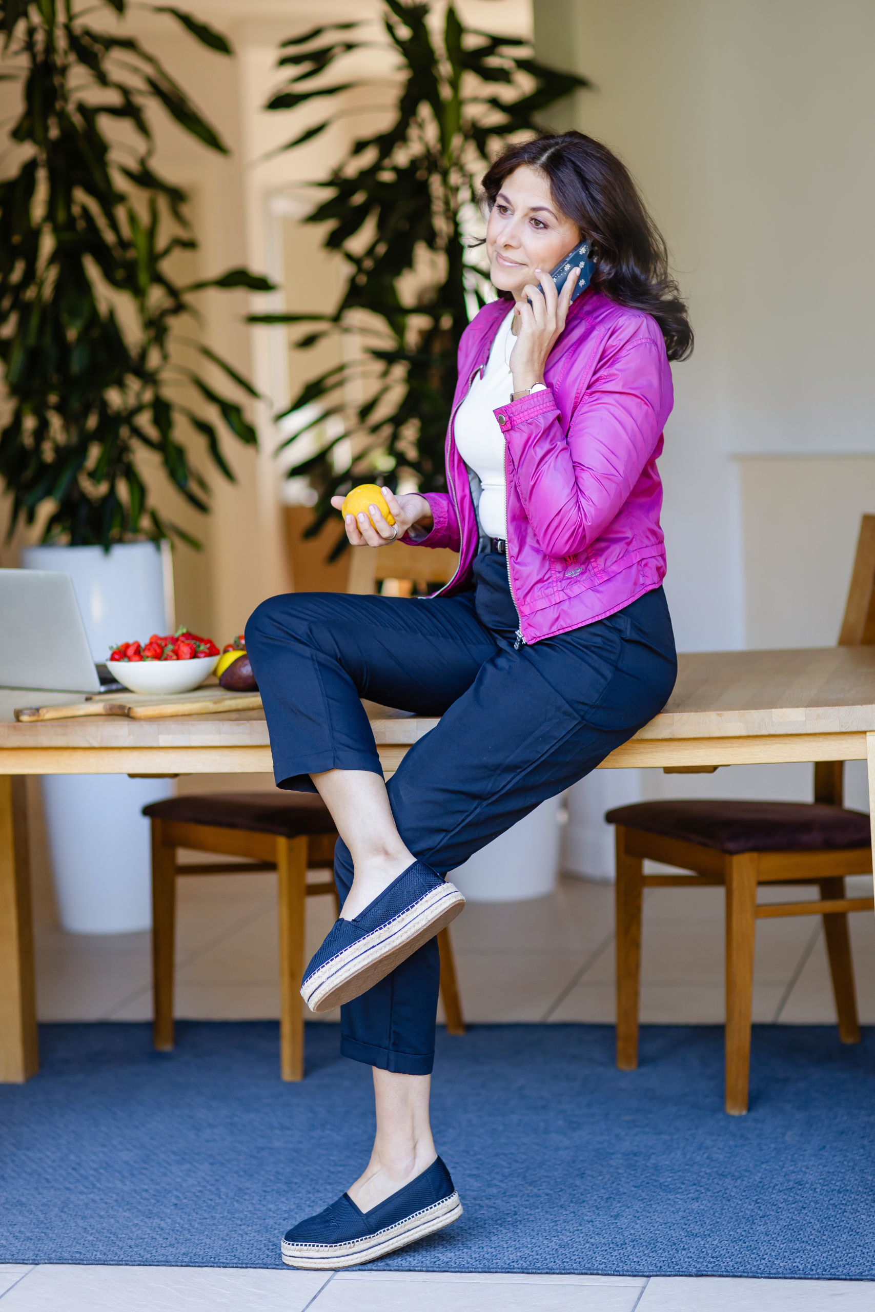 Olga sitzt auf dem Tisch mit dem Handy in der Hand.
